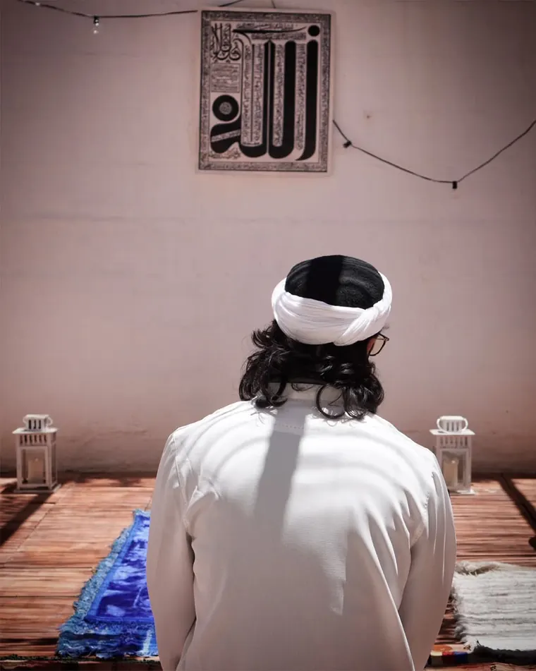 Dr. Ahmad Deeb in prayer, facing calligraphy of the name of God